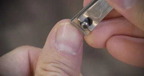 A man cuts his fingernails using a metal nail clipper Stock Footage 321559796
