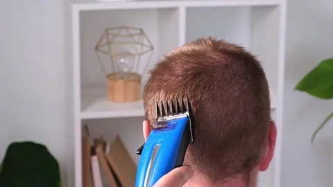 A man cuts his hair with clipper. Cutting a short hairstyle at home. Close-up. Stock Footage 201166313
