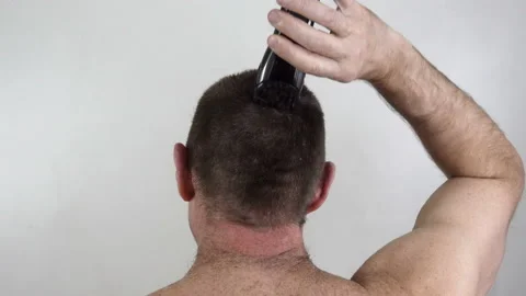 A man cuts his head with a clipper in 4k Stock Footage 152570524