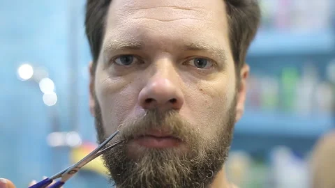 A man cuts his mustache with scissors Video stock 97245615