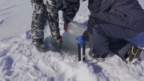 A man cuts a hole in the ice to catch a crab Stock Footage 149381770