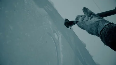 A man cuts ice with a tool, winter city scenery Stock Footage 121752942