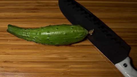  A man cuts a large cucumber. Stock Footage 104657353