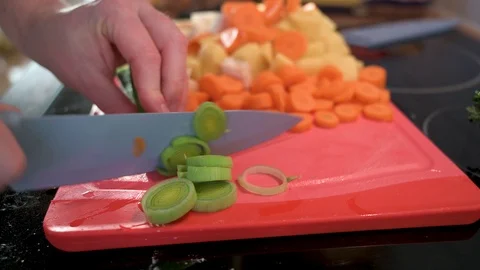 Man cuts leeks into small pieces with a knife Stock Footage 124679146
