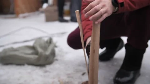 A man cuts a log with an axe into splinters for a fire in winter. Stock Footage 229556554