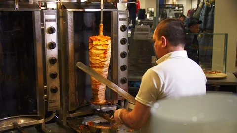 Man cuts meat on grill in cafe kitchen in shopping mall Stock Footage 127748394