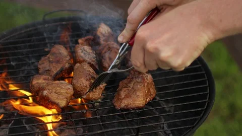 Man cuts meat on the grill on fire Stock Footage 91233213