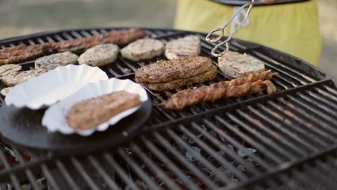 A man cuts meat with a knife on the grill. Delicious and hot steaks. Stock Footage 103480223