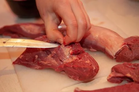 Man cuts meat on the table Stock Photos