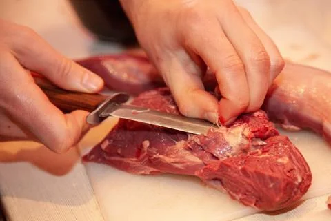Man cuts meat on the table Stock Photos