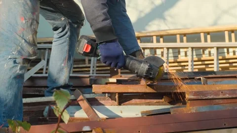 A man cuts metal with a angle grinder in his yard Stock Footage 321940285