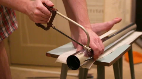 A man cuts a metal leg for the table Stock Footage 102031677