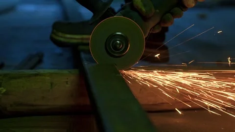A man cuts metal using an angle grinder close-up. Many sparks Stock Footage 318463841