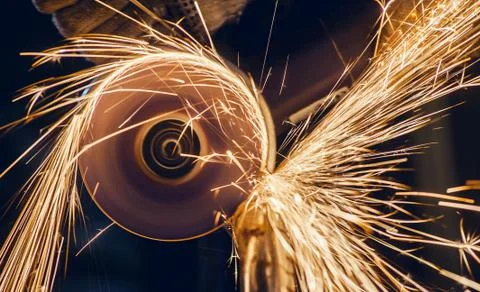 A man cuts metal using an angle grinder close-up. Many sparks Stock Photos