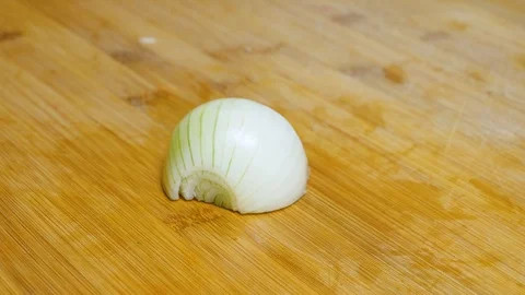 The man cuts the onion and chops the onion. Close shot of a onion. 4K Stock Footage 128590212