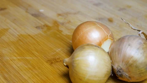 The man cuts the onion and chops the onion. Close shot of a onion. 4K Stock Footage 128590418