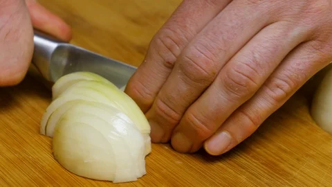 The man cuts the onion and chops the onion. Close shot of a onion. 4K Stock Footage 128591301