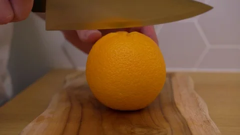The man cuts the orange and cut it into wedges Stock Footage 129056667