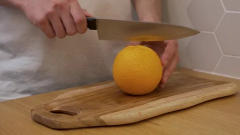 The man cuts the orange and cut it into wedges Stock Footage 129056703