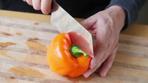 Man cuts orange bell pepper Stock Footage 75427142