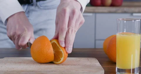 A man cuts an orange 스톡 동영상 247078559