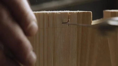 A man cuts out a dovetail on a pine board with a hand jigsaw. dovetail joiner Stock Footage 166340977