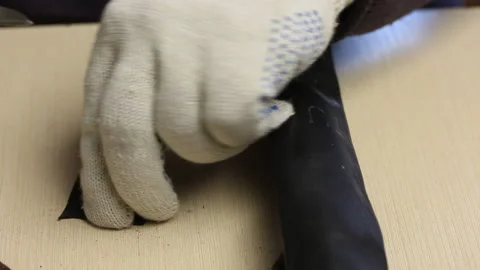 A man cuts a patch out of rubber to seal the puncture site in a bicycle tube. 스톡 동영상 138760564