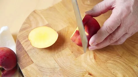 Man cuts up peach Stock Footage 76746944