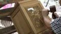 Man cuts a picture with elephants out of wood at a teak factory in Thailand HD Footage