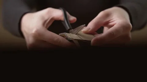 A man cuts off a piece of cardboard with scissors Stock Footage 143236312