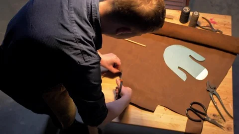 Man cuts a piece of cloth on a table Stock Footage 126721793