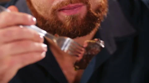 Man cuts off a piece of steak close-up Видео 59083585