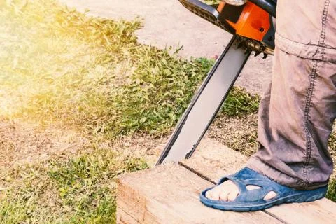 Man cuts a pine timber with a chainsaw Stock Photos