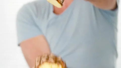 Man cuts pineapple in air holding it in one hand knife in other hand Stock Footage 147646675