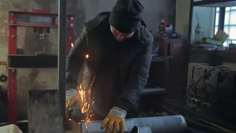 A Man Cuts A Pipe With A Grinder Stock Footage 169311601