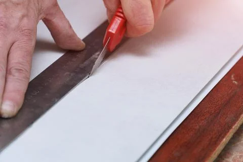 Man cuts a plastic pvc panel with a construction knife Stock-Fotos