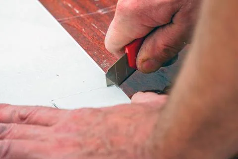 A man cuts a plastic pvc panel with a construction knife 写真素材