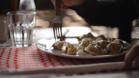 A man cuts on a plate and eats a dumpling Close-up Stock Footage 150274417