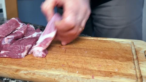 A man cuts the pork Видео 101202117