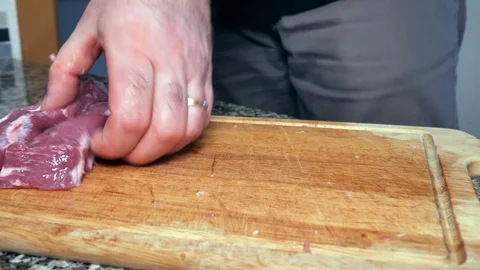 A man cuts the pork Видео 101203043
