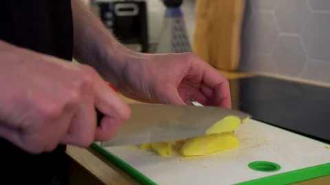 A man cuts the potato on the cutting Board Stock Footage 129058656