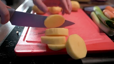 Man cuts potatoes into small pieces with a knife Stock Footage 124679986