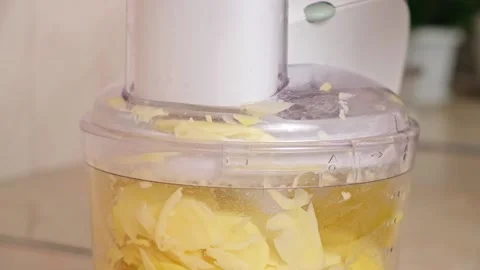 A man cuts potatoes into thin slices in food processor. Preparation of potatoes Stock Footage 229928180
