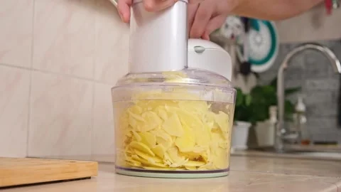 A man cuts potatoes into thin slices in food processor. Preparation of potatoes Stock Footage 230721110