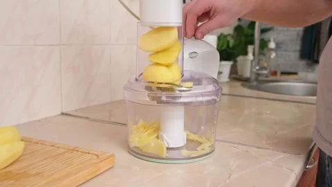 A man cuts potatoes into thin slices in food processor. Preparation of potatoes Stock Footage 231185201