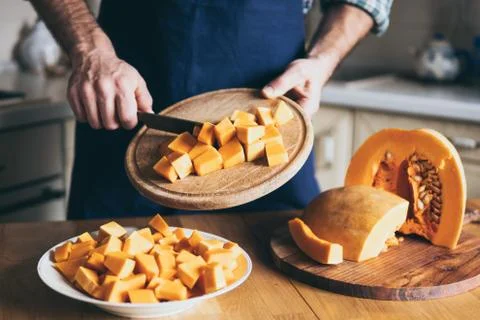 Man cuts pumpkin in the kitchen Stock Photos