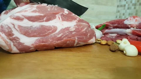 Man cuts raw meat in the kitchen Stock Footage 83460045