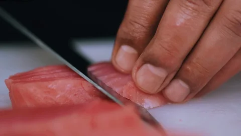 Man cuts raw meat with the knife in kitchen cooking beefsteak preparation Stock Footage 100303172