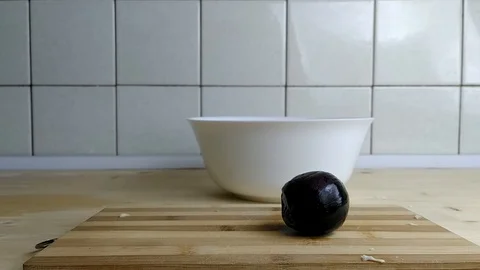 Man cuts a red onion into two halves Video stock 129845311