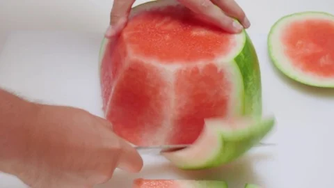Man Cuts the Rind Off a Watermelon with a Chef Knife Stock Footage 79129534